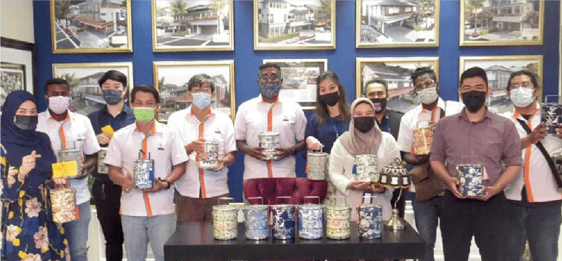 Staff members holding tiffins